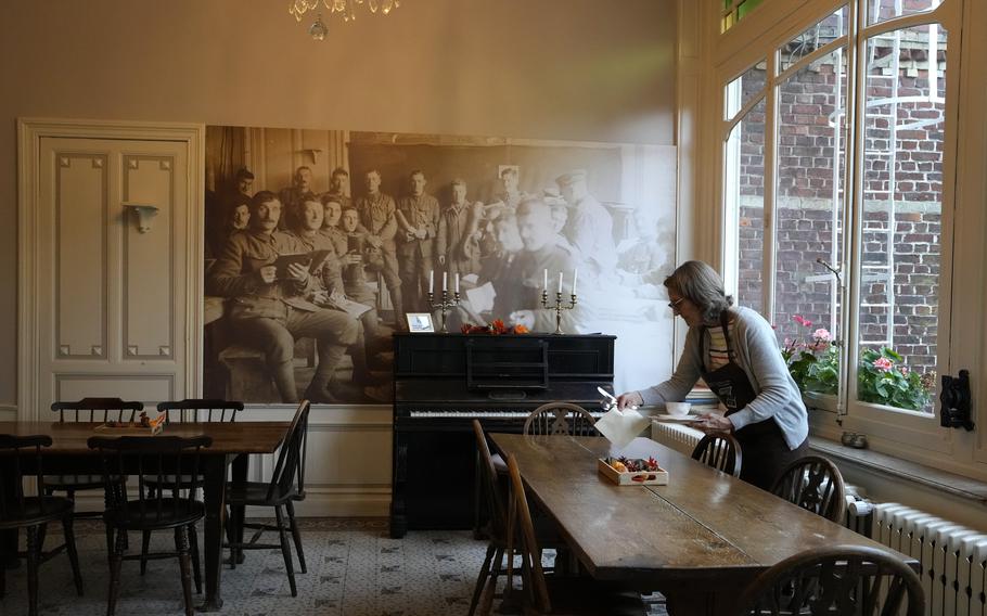 Volunteer Libby Madden, from Bath, England, sets a table in the breakfast room at Talbot House in Poperinge, Belgium, Ypres on Thursday, Nov. 4, 2021. 