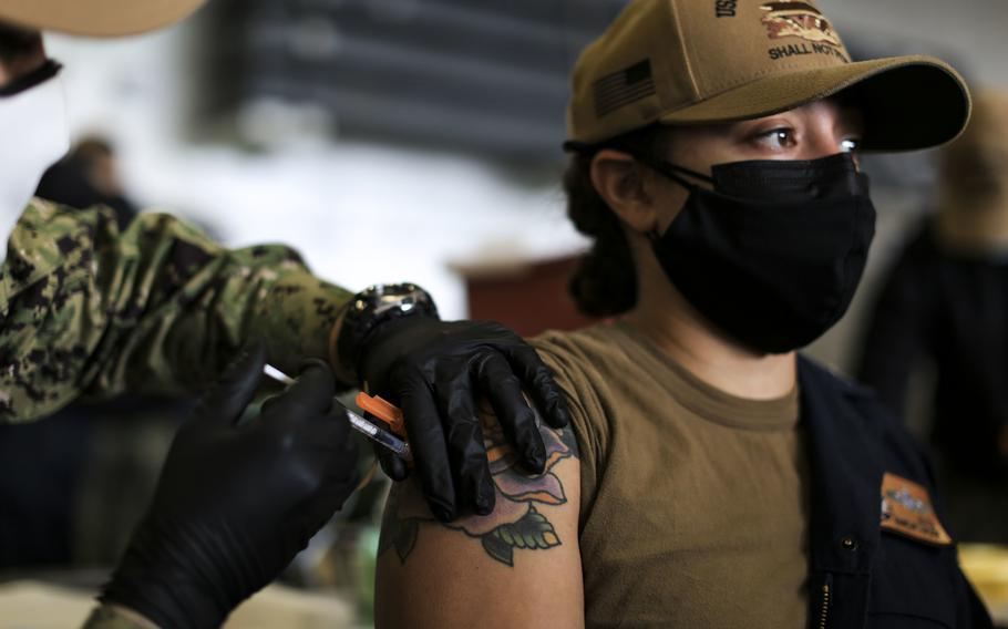 Machinist’s Mate 1st Class Kayla Matos receives a coronavirus booster shot during a vaccine event in the hangar bay aboard USS Abraham Lincoln on Dec. 28, 2021, in San Diego. 