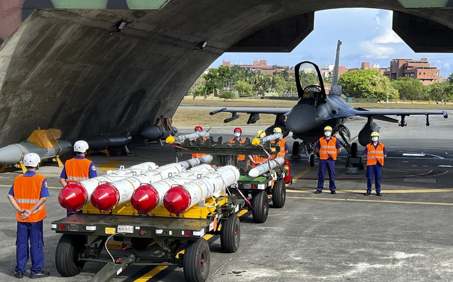 Military personnel stand next to U.S. Harpoon A-84, anti-ship missiles and AIM-120 and AIM-9 air-to-air missiles prepared for a weapon loading drills in front of a U.S. F-16V fighter jet in Taiwan’s southeastern Hualien county, Aug. 17, 2022. 