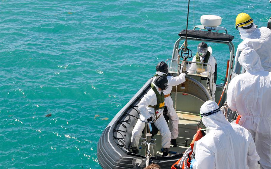 Australian navy sailors from the guided-missile destroyer HMAS Brisbane board an inflatable vessel during search-and-rescue efforts near Lindeman Island in Queensland, Australia, Saturday, July 29, 2023. 