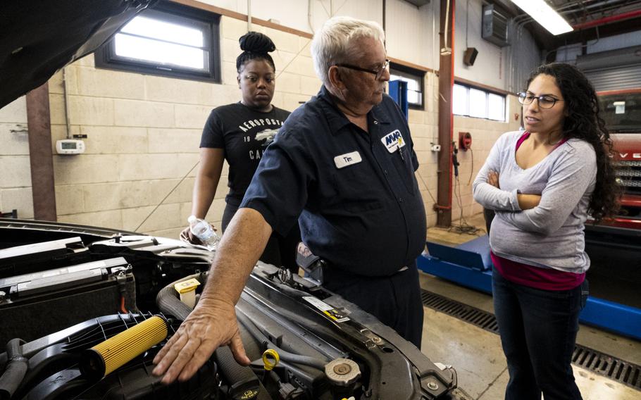 Tim Daubert instructs a small class on how to change oil in a car from the Naval Station Norfolk Auto Skills building in Norfolk, Va., on March 24, 2023.
