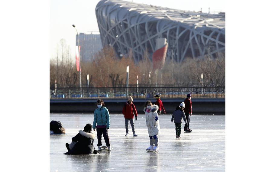 People skate on a frozen river at Beijing Olympic Park on Thursday, Jan. 13, 2022.