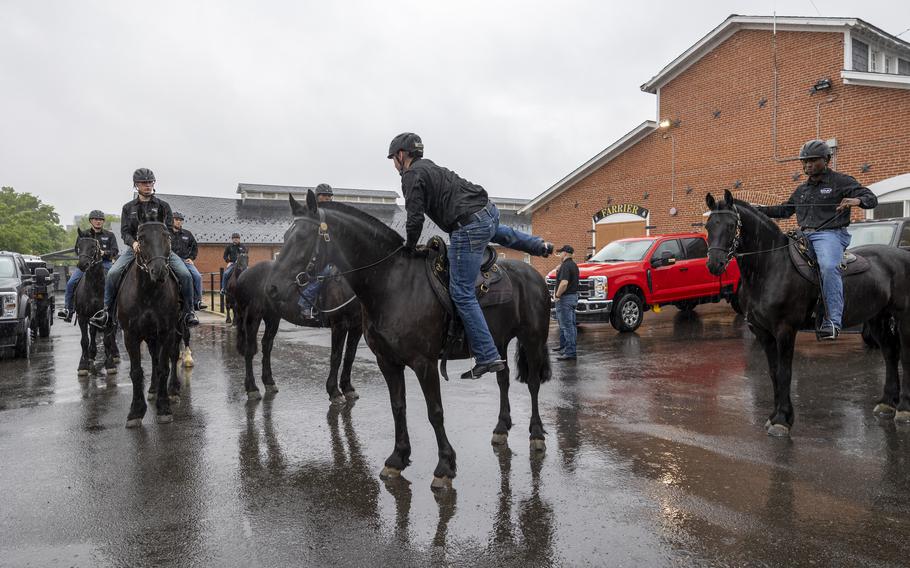 Soldiers climb atop their horses.