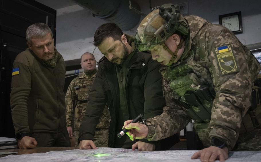 Ukraine President Volodymyr Zelenskyy and the commander of Ukraine’s ground forces Col.-Gen. Oleksandr Syrski, right, look at a map during their visit to the front line city of Kupiansk, Kharkiv region, Ukraine, on Nov. 30, 2023.