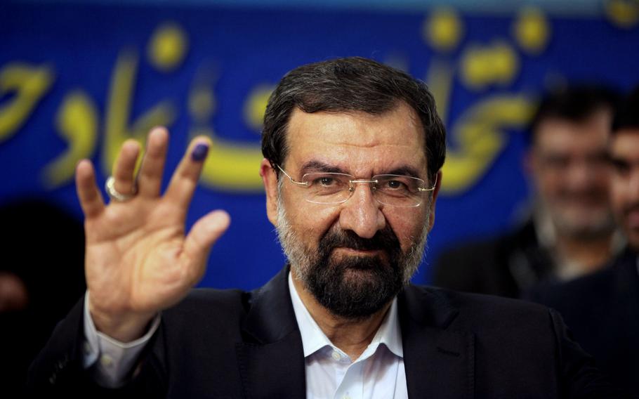 FILE - Mohsen Rezaei waves to reporters after registering as a presidential candidate, in Tehran, Iran, May 10, 2013. Argentina’s Foreign Ministry said Tuesday, Jan. 11, 2022, that the appearance of Rezaei, at the investiture of Nicaragua’s president on Monday was “an affront to Argentine justice and to the victims of the brutal terrorist attack″. Rezaei, a former leader of Iran’s paramilitary Revolutionary Guard, is wanted by Argentina on an Interpol “Red Notice” alleging he was involved in the 1994 bombing of a Jewish center in Buenos Aires that killed 85 people. (AP Photo/Vahid Salemi, File)