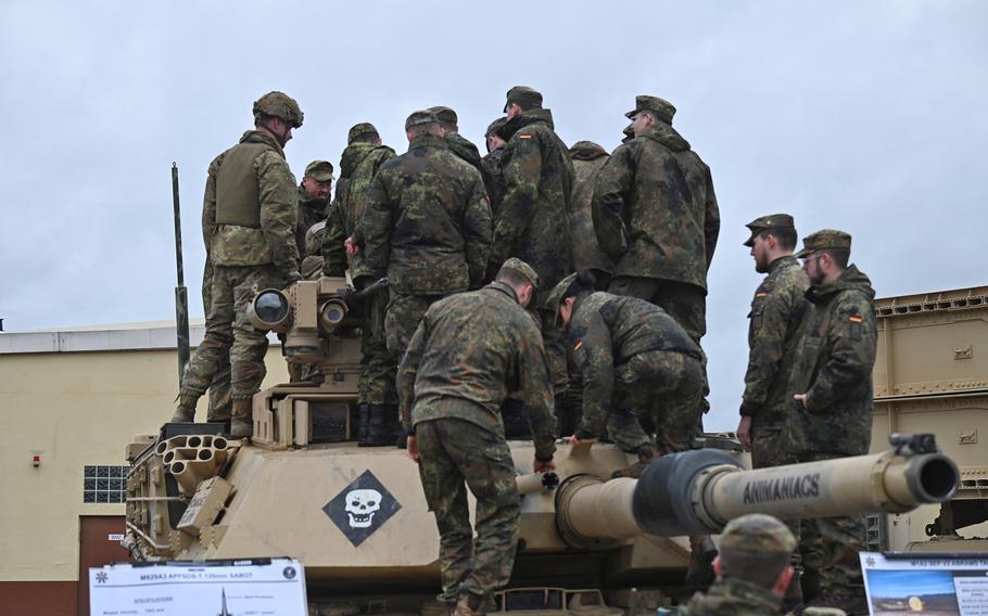 Soldiers from the German Army NCO School climb aboard an M1A2 Abrams tank Feb. 22, 2024, to learn more about U.S. military equipment from 1st Battalion, 37th Armored Regiment troops during an exchange in Grafenwoehr, Germany.