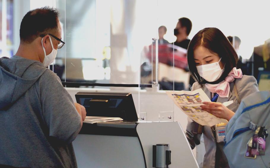 An airline agent assists a traveler at Haneda International Airport, Japan, on Nov. 10, 2021. 