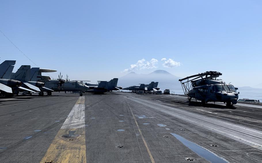 Aircraft are parked on the flight deck of the USS Harry S. Truman with Mount Vesuvius in the background on May 11, 2022. 