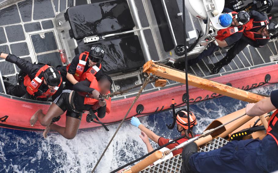 A Coast Guard Cutter Dependable (WMEC 626) small boat crew transfers a Haitian child to the cutter during a search and rescue mission in heavy seas, which resulted in the successful rescue of all 33 aboard a sinking vessel 6 miles off Haiti’s coast, Jan. 22, 2024. 