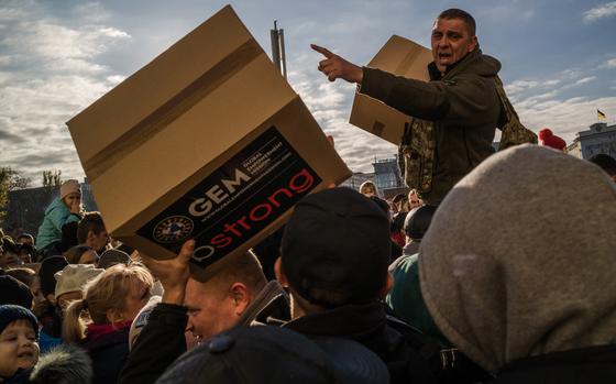 People collect humanitarian aid boxes in Freedom Square in Kherson, Ukraine, in November. As winter approaches, German officials have said they expect an uptick in arrivals from the front lines in Ukraine. MUST CREDIT: Photo for The Washington Post by Wojciech Grzedzinski.