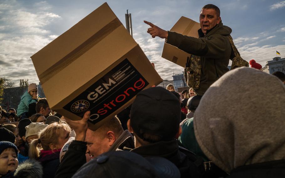 People collect humanitarian aid boxes in Freedom Square in Kherson, Ukraine, in November. As winter approaches, German officials have said they expect an uptick in arrivals from the front lines in Ukraine. 