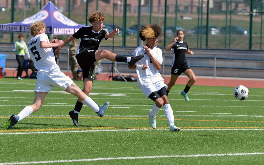 Alconbury’s Keiran Daley gets off a shot against Ansbach’s Sam Hanson, left, and Donovan Howard in the Division III boys final at the DODEA-Europe soccer championships in Ramstein, Germany, May 22, 2025. Ansbach took the title with a 1-0 win.