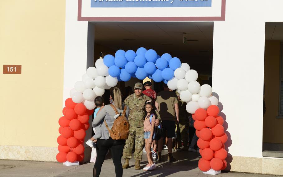 Parents pose for photos with children Monday, Aug. 22, 2022, before the first day of school at Aviano Elementary School in Italy.