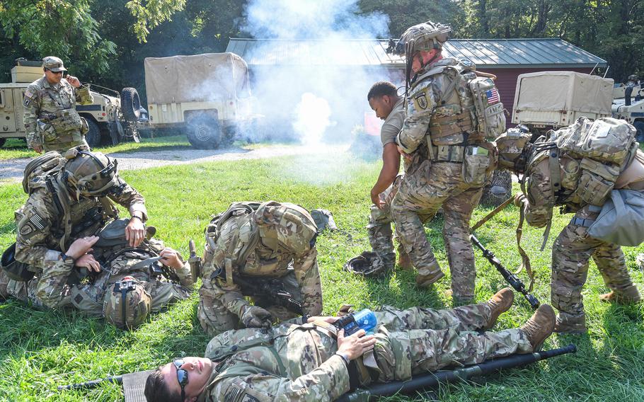 Security Force Assistance Brigade soldiers — known as “advisors” — help soldiers with a simulated injuries as indirect fire strikes in the background during a pre-deployment training exercise Aug. 23, 2023, at Muscatatuck Training Center in Indiana. 