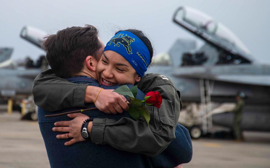 An aviator assigned to Strike Fighter Squadron (VFA) 213, “Blacklions,” hugs a loved one after their homecoming flight to Naval Air Station Oceana, Jan. 15, 2024.