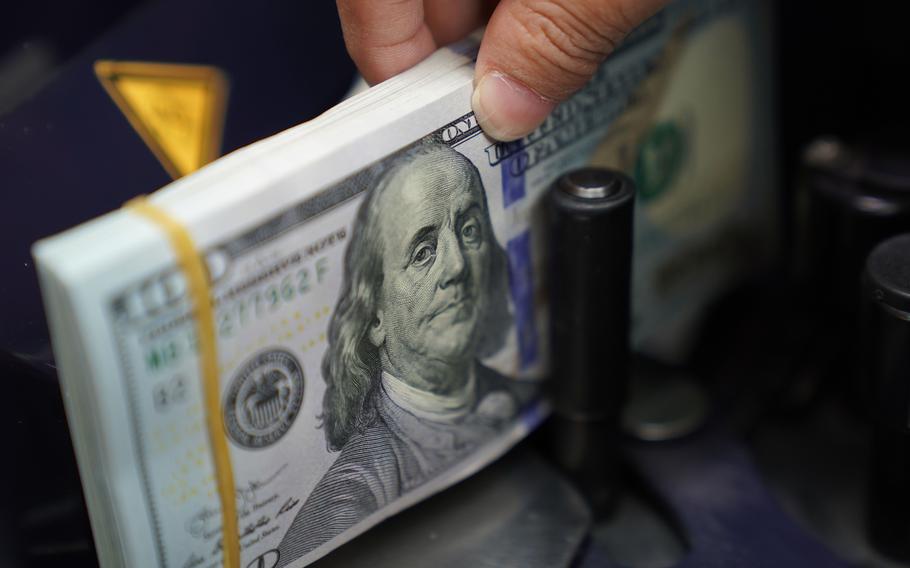 A worker counts U.S. dollar bank notes at a currency exchange office in Jakarta, Indonesia, on Wednesday, March 2, 2022. 