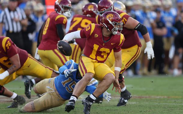 Caleb Williams (13) of the USC Trojans is flushed from the pocket by Laiatu Latu (15) of the UCLA Bruins during the second half of a game at United Airlines Field at the Los Angeles Memorial Coliseum on Nov. 18, 2023, in Los Angeles. (Sean M. Haffey/Getty Images/TNS)