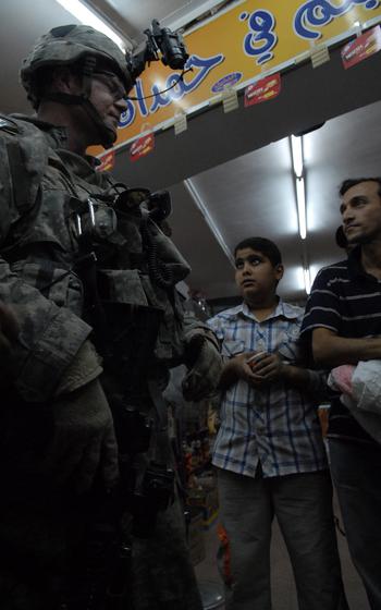 2nd Lt. Jedidiah Wentz talks to residents inside a shop during a patrol in the Gazaliah district of western Baghdad. Violence has been relatively low since Wentz's unit arrived in October, and new shops continue to open, officers say. 