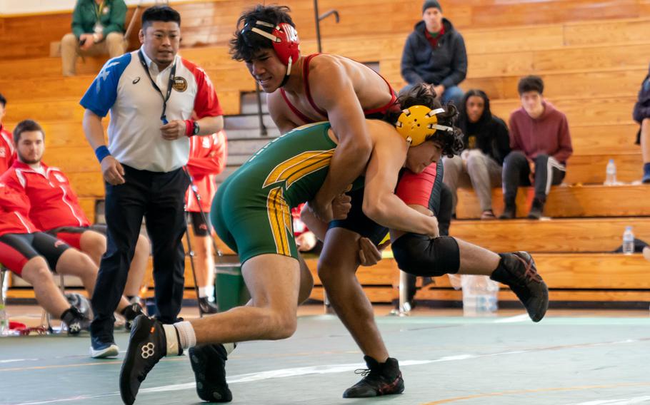 Robert D. Edgren's Sidney Cogswell makes a move against Nile C. Kinnick's Kevin Ramos-Kaula at 158 pounds during Saturday's DODEA-Japan wrestling tri-meet. Ramos-Kaula won by technical fall and the Red Devils took the dual meet 53-5.