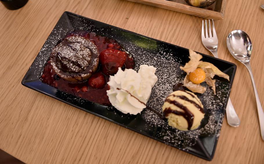 The chocolate souffle is one of the many dessert items available at Restaurant MAX in Winnweiler, Germany. It comes with a fruit sauce, whipped cream and a scoop of ice cream.