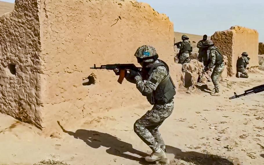 In this handout photo released by Russian Defense Ministry Press Service, Soldiers aim their weapons during joint war games conducted by Russian and Tajik troops at the Momirak firing range about 20 kilometers (about 12 miles) north of the Afghan border, Tajikistan, Friday, Oct. 22, 2021.
