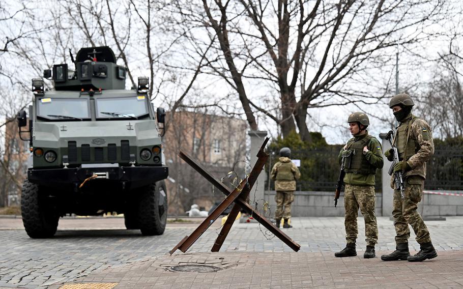 Ukrainian Military Forces servicemen block a road in the so-called government quarter in Kyiv on Feb. 24, 2022, as Russia's ground forces invaded Ukraine from several directions. 