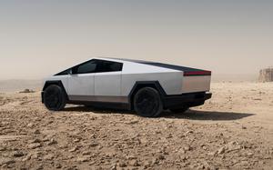 A Tesla Cybertruck is parked in the desert.