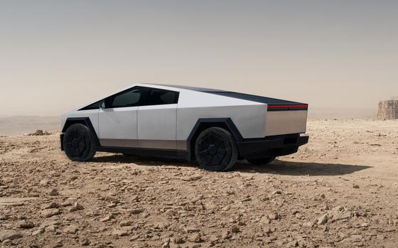 A Tesla Cybertruck is parked in the desert.