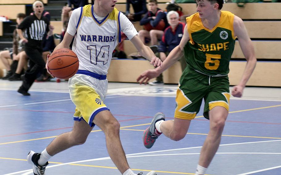 Wiesbaden’s Collin Koschnik drives toward the basket while SHAPE’s Bela Clobes defends during pool play of the Division I DODEA European Basketball Championships on Wednesday at Ramstein High School on Ramstein Air Base, Germany.