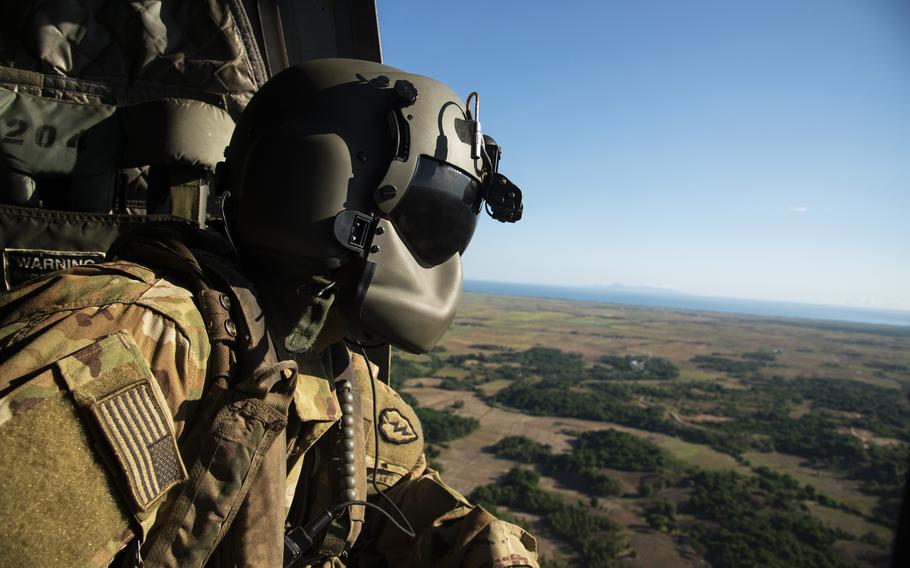 Army Spc. Samuel Sosa, a CH-47F Chinook repairer with 3rd Battalion, 25th Aviation Regiment, flies over Batanes, Philippines, on May 5, 2024, during the Balikatan exercise. 