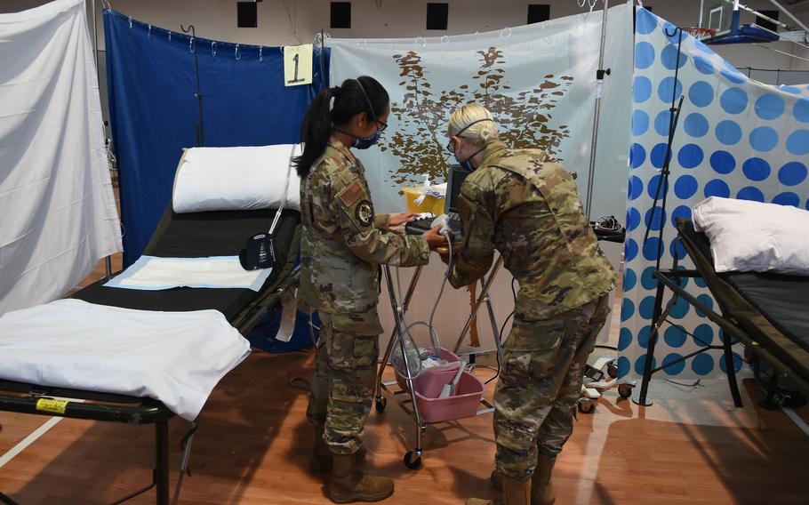 Capt. Danielle Holland and Maj. Suzanne Stammler, Air Force OB-GYN physicians with the 48th Medical Group at RAF Lakenheath, England, set up an a portable ultrasound device inside a field hospital at Ramstein Air Base, Germany, Sept. 10, 2021, to care for evacuees from Afghanistan. Holland and Stammler alternate 24-hour shifts to provide for the health care needs of women temporarily staying at Ramstein and Rhine Ordnance Barracks.