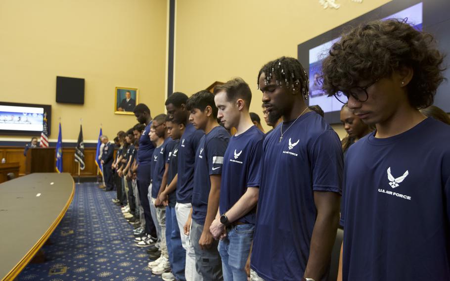 Airmen with their heads down in observance of prayer on National Signing Day.