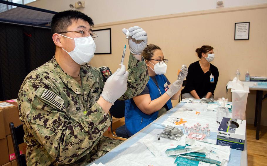 Medical workers prepare syringes with doses of the Pfizer COVID-19 vaccine this spring at Yokosuka Naval Base, Japan.