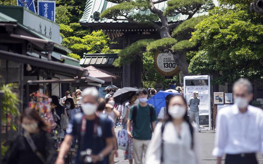 People wear coronavirus masks last month while visiting the Hasedera Buddhist temple in Kamakura, Japan.