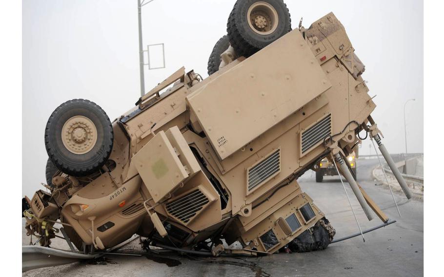 A Mine-Resistant Ambush-Protected vehicle rests on its turret and hood after a rollover. 