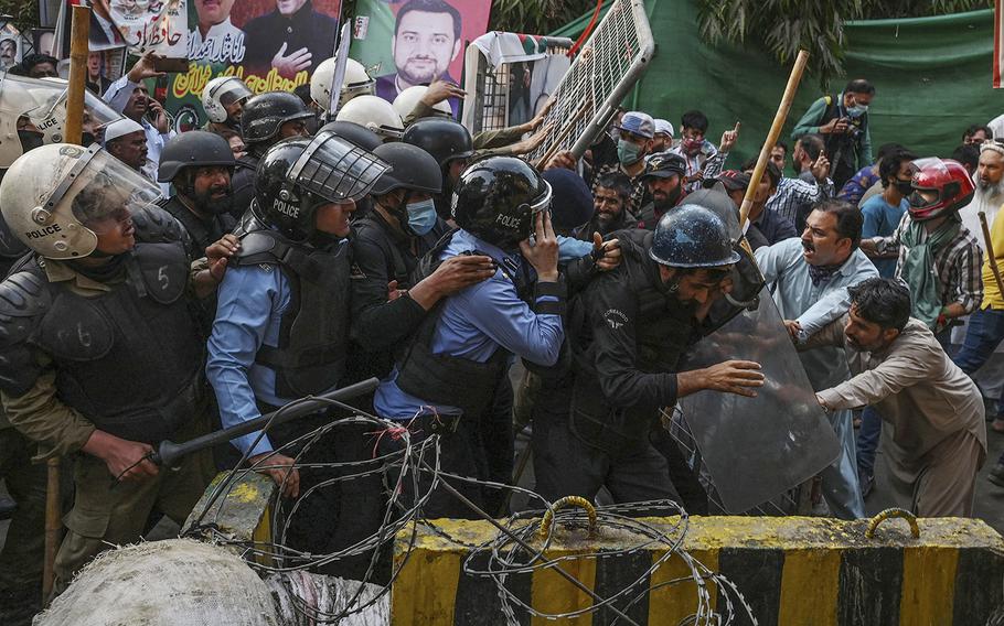 Supporters of former prime minister Imran Khan try to stop riot police scuffle outside Khan’s house to prevent officers from arresting him, in Lahore, Pakistan on March 14, 2023. 