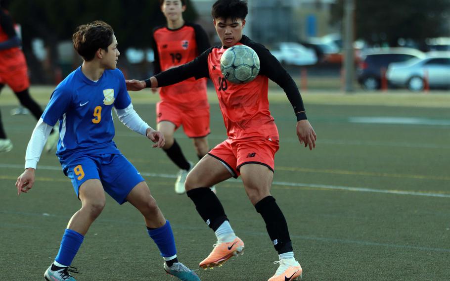 Nile C. Kinnick's Nick Moore tries to settle the ball in front of Yokota's Evan Horne during Wednesday's DODEA-Japan boys soccer match. The host Red Devils won 2-0.