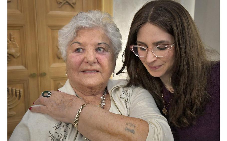 Holocaust survivor Lilly Malnik shows a Nazi-era concentration camp serial number tattooed on her left arm, as her granddaughter Miriam Ezagui looks on. 