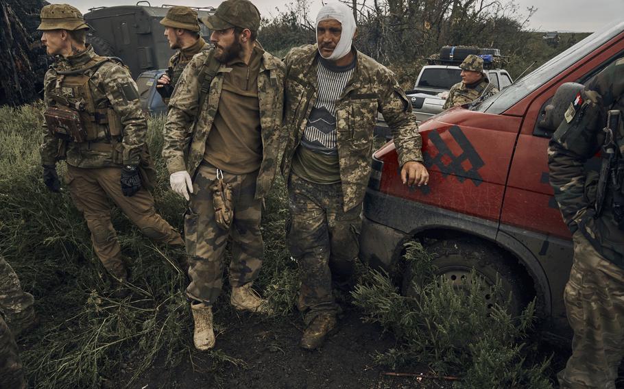 A Ukrainian soldier helps a wounded fellow soldier on the road in the freed territory in the Kharkiv region, Ukraine, Monday, Sept. 12, 2022. Ukrainian troops retook a wide swath of territory from Russia on Monday, pushing all the way back to the northeastern border in some places, and claimed to have captured many Russian soldiers as part of a lightning advance that forced Moscow to make a hasty retreat.