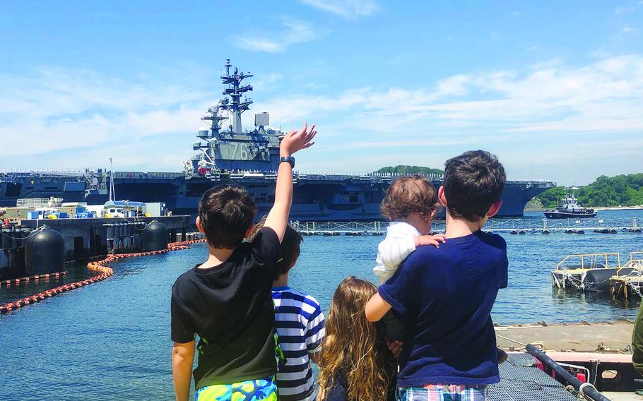 The children of a USS Ronald Reagan sailor watch as the aircraft carrier departs Yokosuka Naval Base, Japan, May 22, 2019.