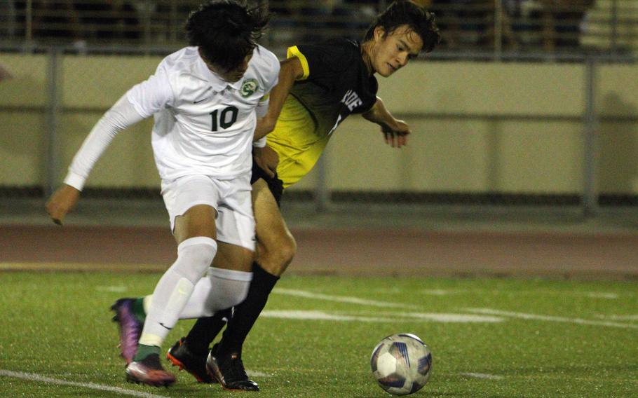 Kubasaki's Seira Fowler and Kadena's Tuck Renquist tussle for the ball during Friday's DODEA-Okinawa soccer match. The Dragons won 2-0.
