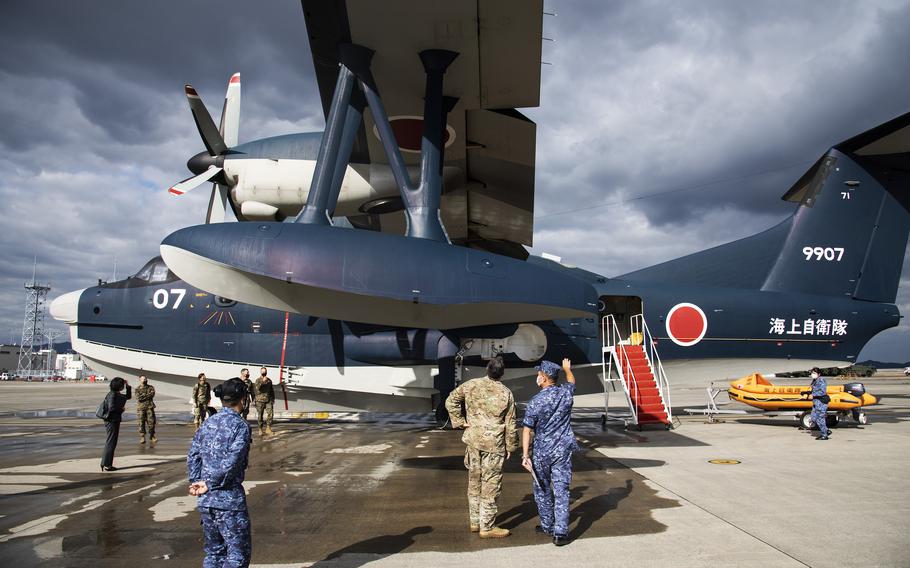 Capt. Koichi Washizawa of the Japan Maritime Self-Defense Force gives a tour of the ShinMaywa US-2 seaplane to the deputy commander of Air Force Special Operations Command, Maj. Gen. Eric Hill, at Marine Corps Air Station Iwakuni, Japan, Tuesday, Nov. 9, 2021.