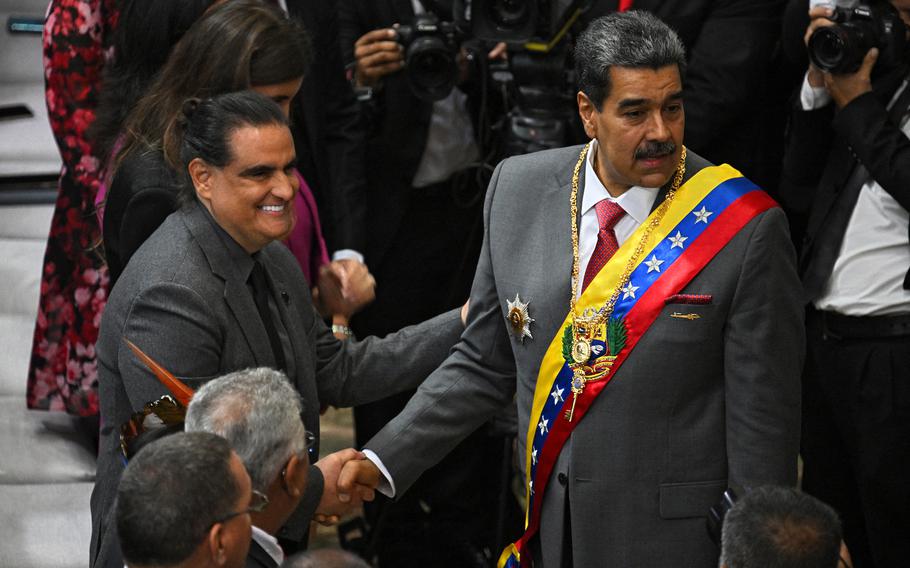 Venezuelan President Nicolas Maduro (right) shakes hands with Colombian-born businessman Alex Saab upon arriving at the National Assembly headquarters to give his state of the nation address to parliament, in Caracas on Jan. 15, 2024.