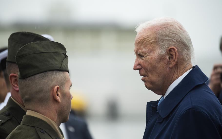 President Joe Biden chats with Col. Richard Rusnok, commander of Marine Corps Air Station Iwakuni, and and Sgt. Maj. Adam Gharati after arriving at the base in Japan, Thursday, May 18, 2023.