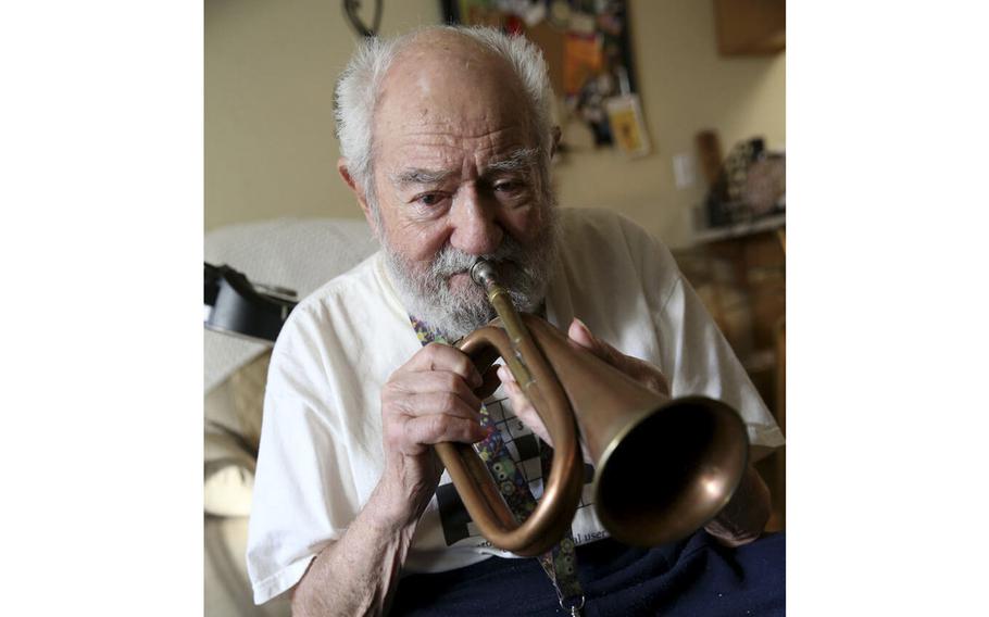 U.S. Army Air Corps veteran and ex-prisoner of war Vincent Shank, then-103, plays the bugle he used while he was a POW during an interview at his Las Vegas home Friday, Dec. 13, 2019.