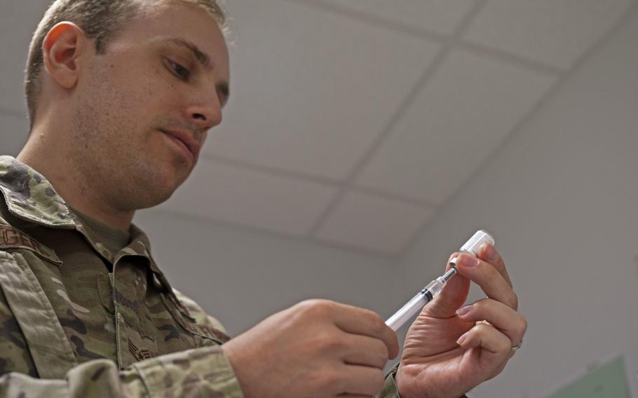 U.S. Air Force Staff Sgt. Joseph Holweger, 86th Medical Group noncommissioned officer in charge of the immunizations clinic, prepares a vaccine at Ramstein Air Base, Germany, Aug. 18, 2022. 