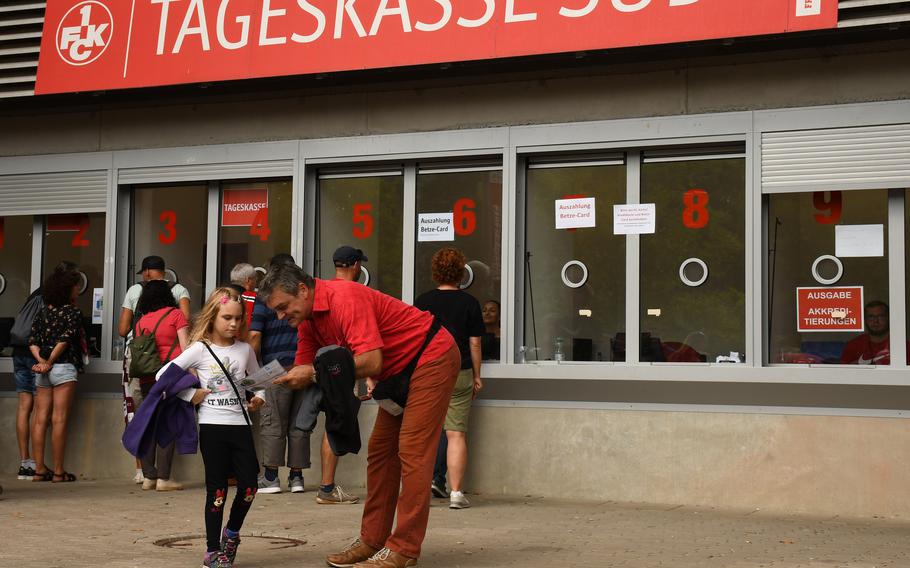 A young girl looks at her ticket ahead of an FC Kaiserslautern soccer game at Fritz Walter Stadium, Sunday, Aug. 28, 2022.