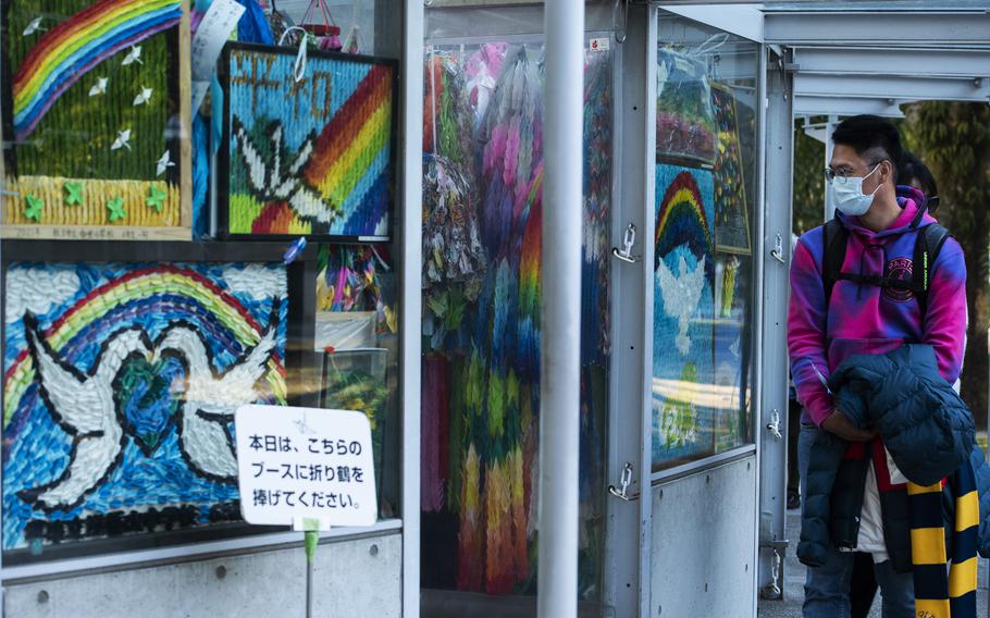 Jason Wang, visiting from Taiwan, looks at origami cranes displayed at Peace Memorial Park in Hiroshima, Japan, Feb. 28, 2023.