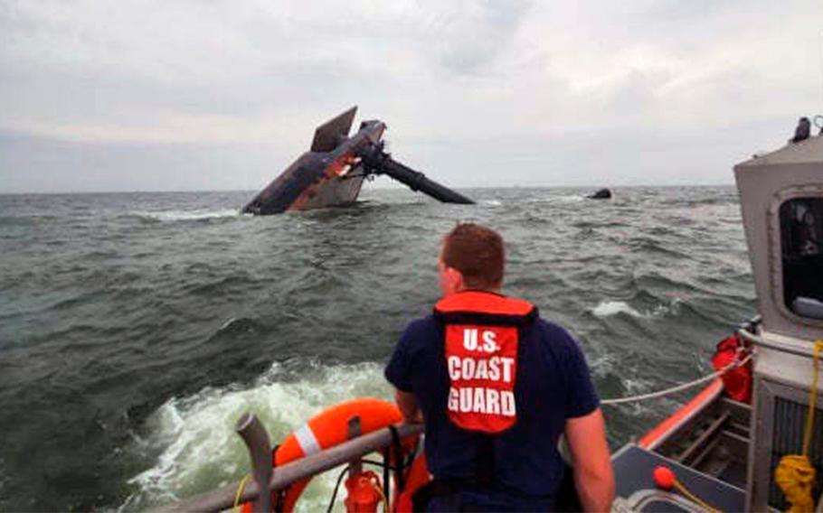 A Coast Guard Station Grand Isle 45-foot Response Boat-medium boat crew member searches for survivors near the capsized SeaCor Power. The Seacor Power, an oil industry vessel, flipped over April 13, 2021 in a microburst of dangerous wind and high seas.