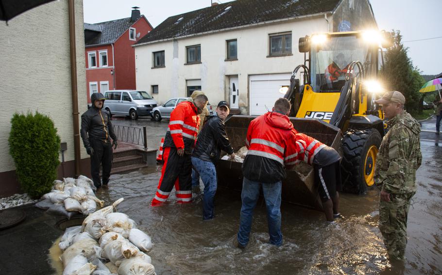 Airmen with the 52nd Civil Engineer Squadron from Spangdahlem Air Base, Germany, work with German first responders and community members to lay sandbags in the town of Binsfeld, Germany, July 14, 2021. About 20 military families at Spangdahlem were displaced by the floods and are being housed in temporary lodging on base.